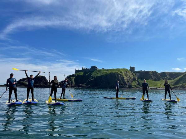 Stonehaven Paddleboarding in North Sea with Dunnottar Castle in background